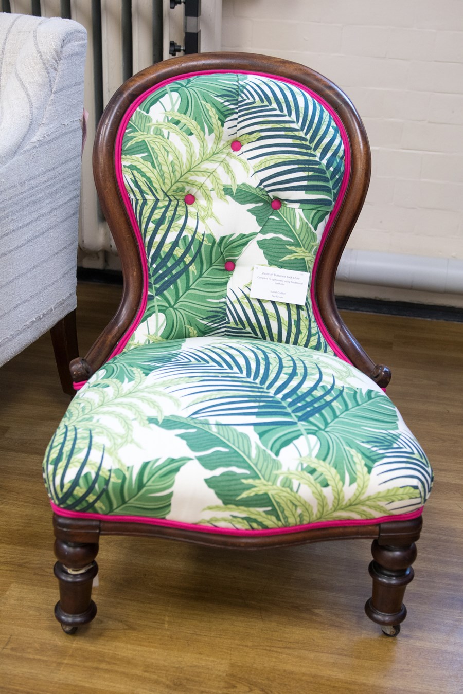 A wooden char upholstered with palm leaf print