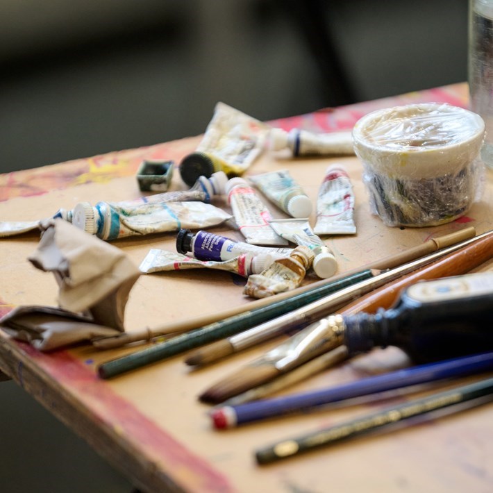 A table of brushes and paint tubes