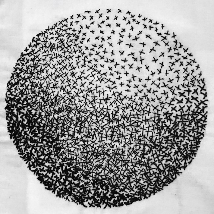 Black hand stitching on white fabric