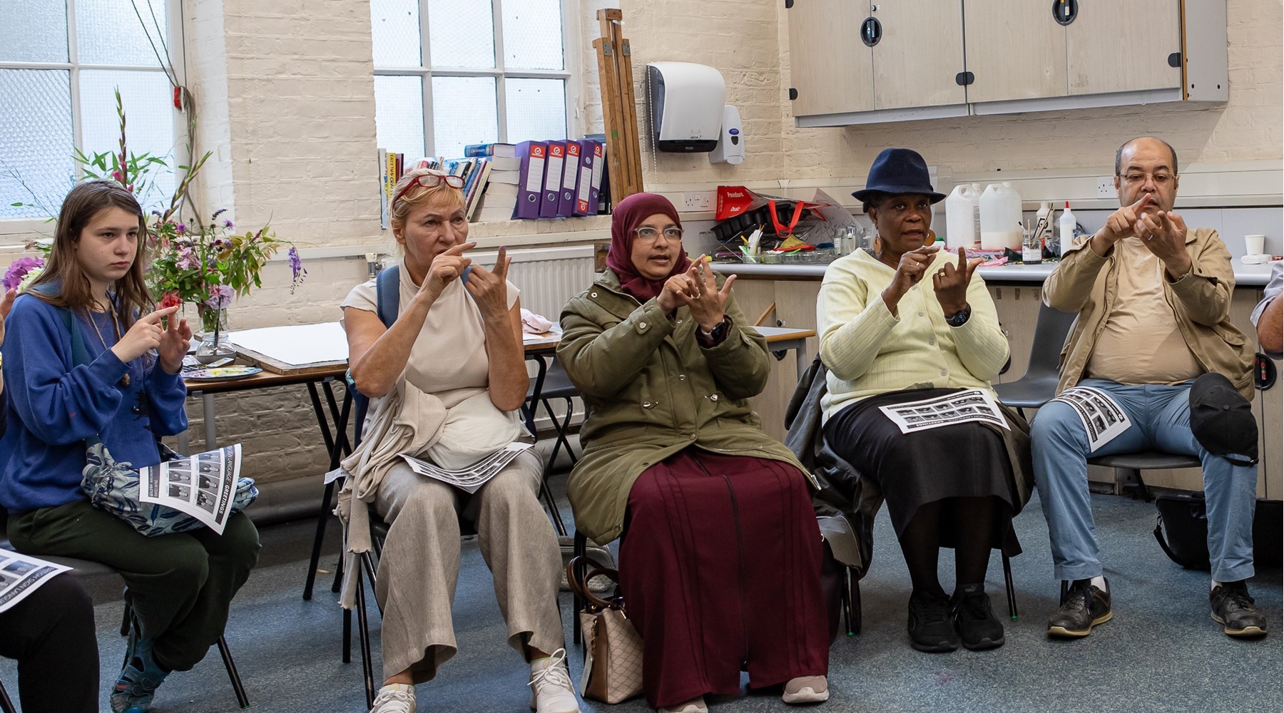 a group of learners trying to learn British Sign Language