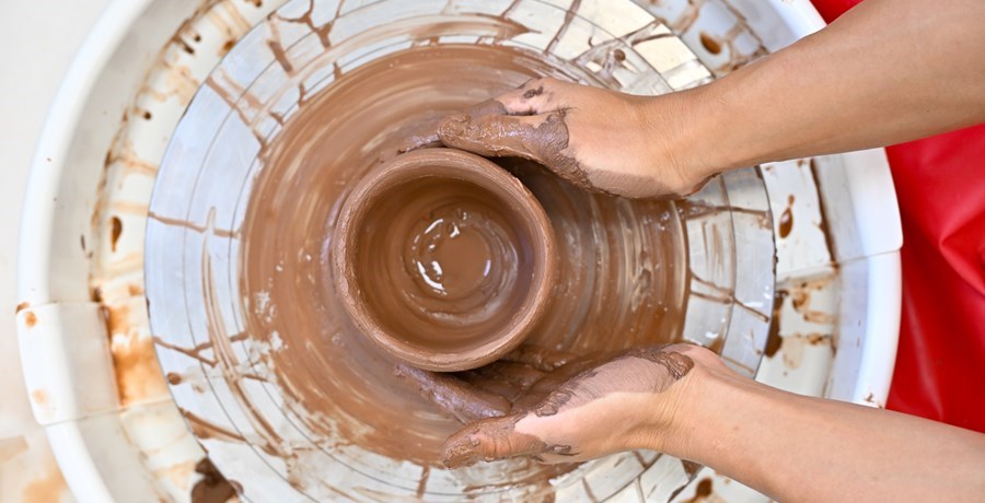 Overhead view of someone working at a pottery wheel