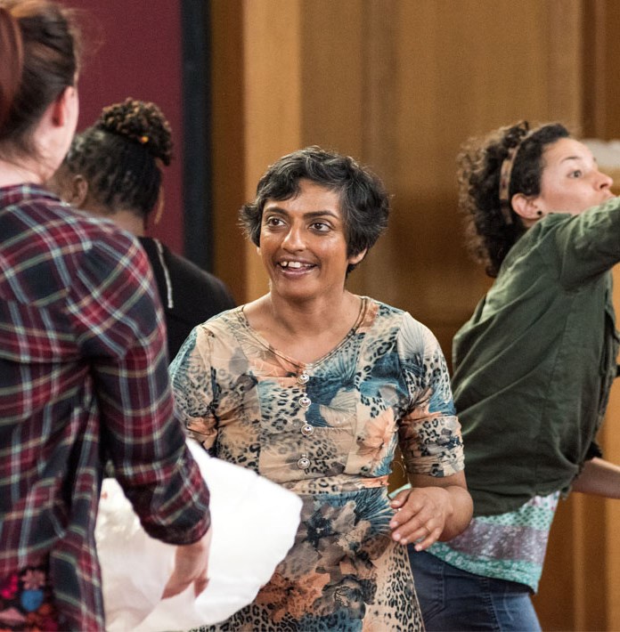 Two woman throwing a balloon bag to each other