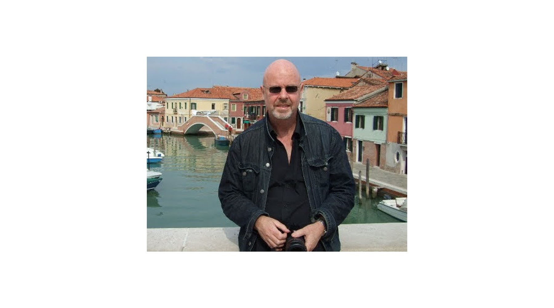 Man in dark jacket and shirt and sunglasses