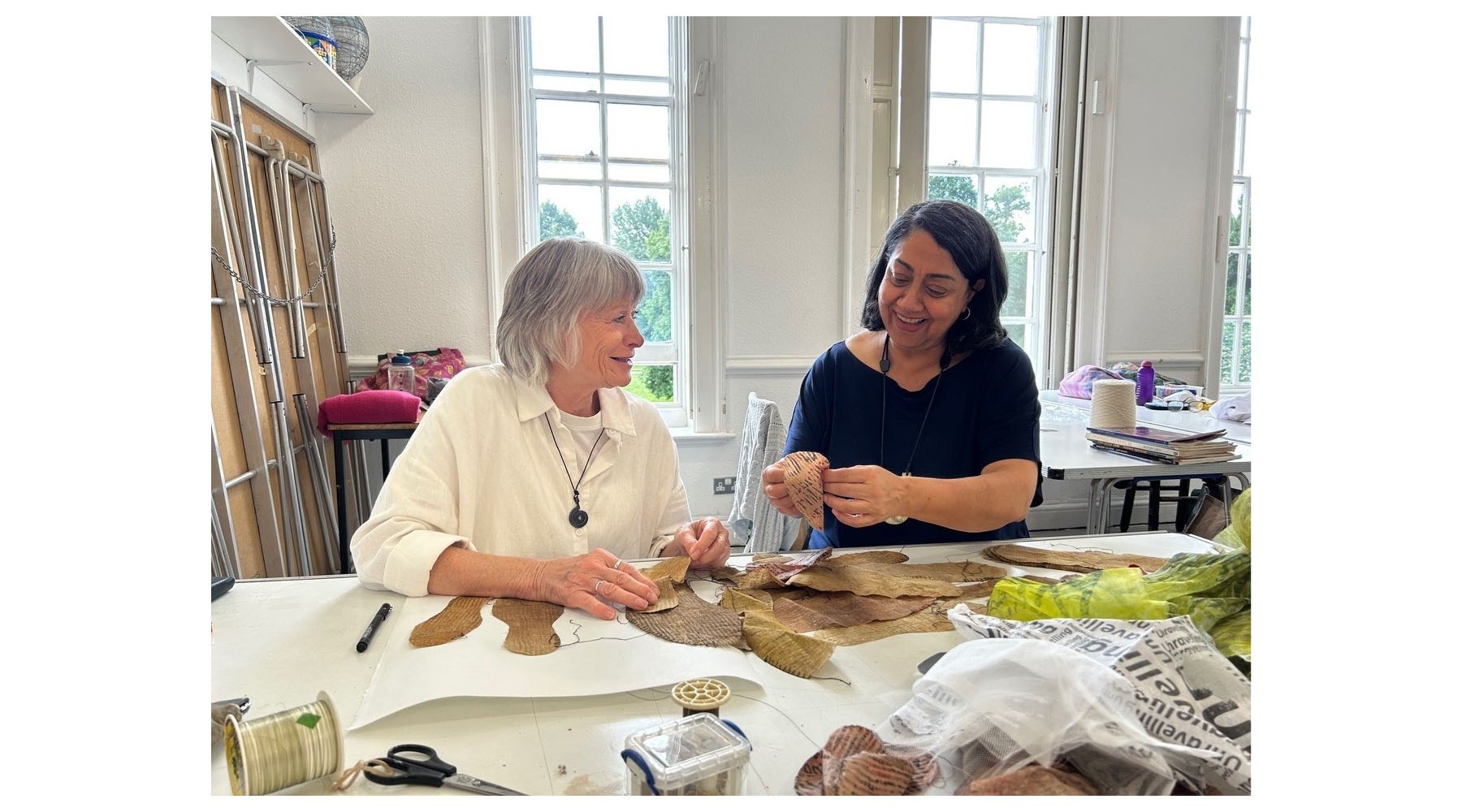 Two women working with fabrics at a table