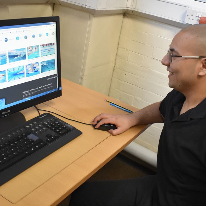 Man working at a computer and holding the mouse